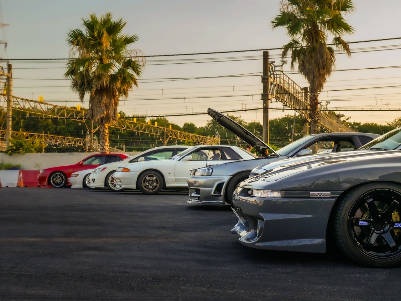 Lineup of classic JDM cars at a car meet in Tokyo, Japan, featuring Nissan and Toyota models.