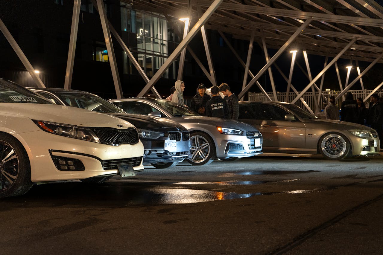 Captivating night scene of a car meetup in Waterloo with cars lined up under city lights.